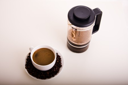 Coffe in plunger and cup with beans