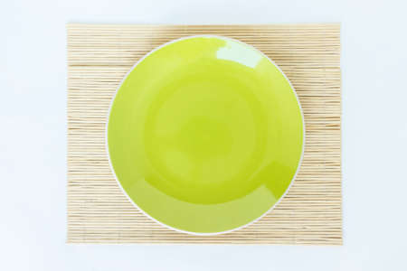 green plate empty and bamboo, mat on white background