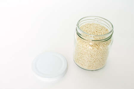 white sesame seed in jar on white backgroundの写真素材