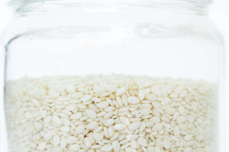 white sesame seed in jar on white backgroundの写真素材