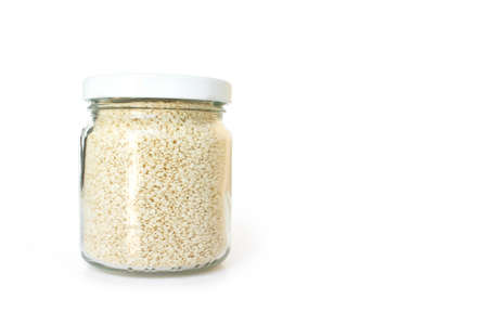white sesame seed in jar on white backgroundの写真素材