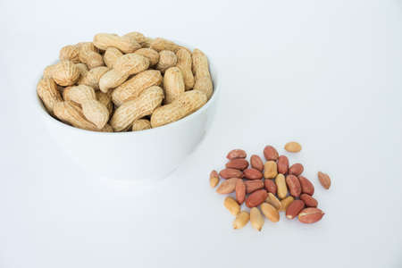 peanut pile in white bowl top view on white backgroundの写真素材