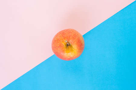 red apple on pink blue rose quartz serenity backgroundの写真素材