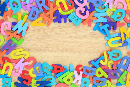 alphabet letter wood pile frame or border top view on wooden backgroundの写真素材