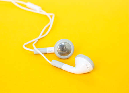 earbuds or earphones on yellow backgroundの写真素材