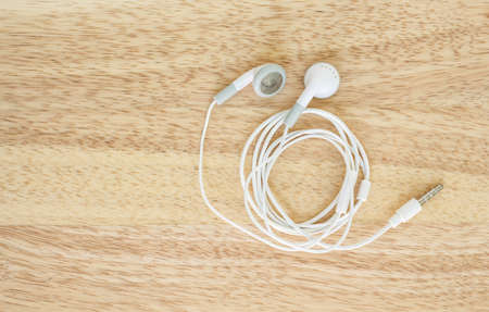 earbuds or earphones top view on wooden backgroundの写真素材