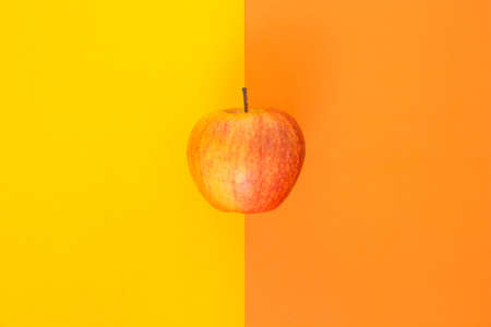 red apple on orange and yellow backgroundの写真素材
