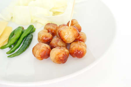 Grilled sausage ball on a white plate on white background.の写真素材