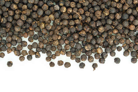 black peppercorns heap top view on white background.