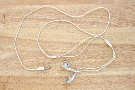 earbuds or earphones top view on wooden background