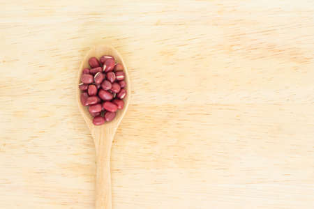 red bean seed spoon top view on wooden backgroundの写真素材
