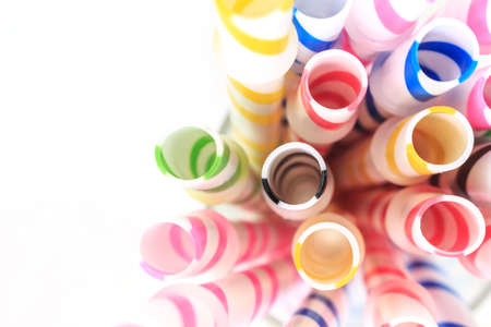 Striped drink straws in different colors on white background.の写真素材