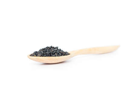 Heap of black sesame on wooden spoon on white background.
