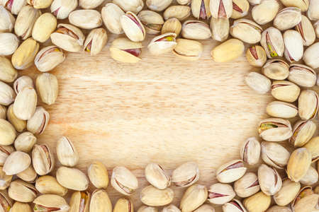 pistachio top view frame or border on wooden background.の写真素材