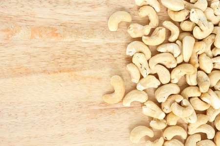 heap cashews top view frame or border on wooden background.の写真素材
