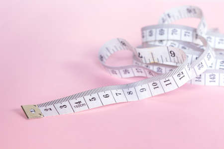 measure tape tool of sewing work on pink background.