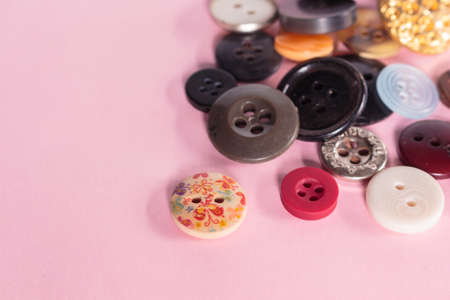sewing button on pink background.