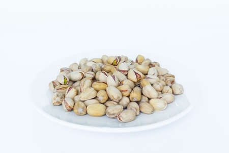 pistachio in plate on white background.