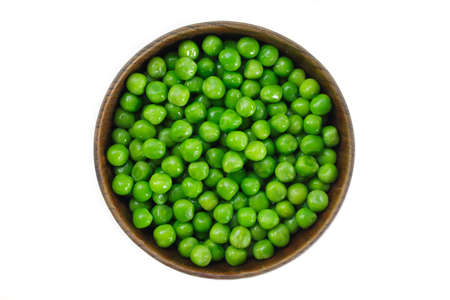 green peas on wooden bowl on white background.