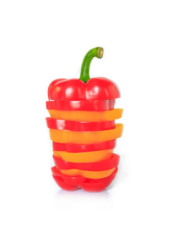 red and yellow bell pepper cut half into pieces on white backgroundの写真素材