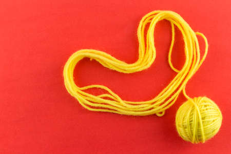 yarn color yellow on red background.の写真素材