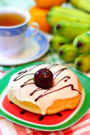A Glazed Donut and some fruits for evening teaの写真素材