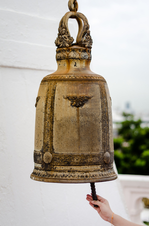 Buddhist ringing the bell to worship the Buddha.