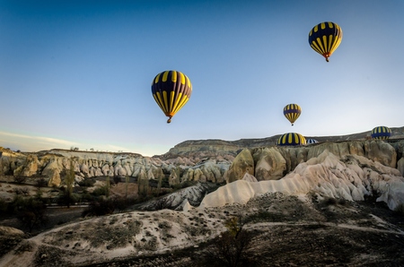 Hot air balloon flying overv olcanic rock landscape, Cappadocia, Turkeydのeditorial素材