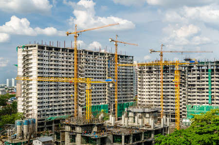 Construction site, Cranes working on construct building over blue sky.