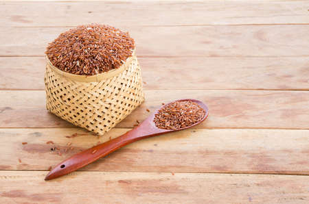 rice berry in wicker container and wooden spoonの写真素材
