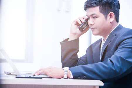 young business man typing laptop, office man workingの写真素材
