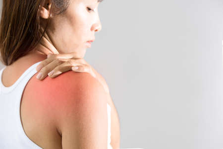 woman holding hand on skin around right shoulder joint with inflammation color の写真素材