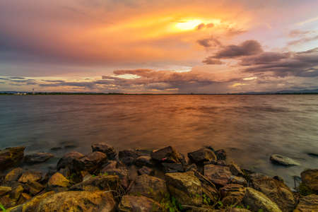Landscape small lake with sunset with stone at foregroundの写真素材