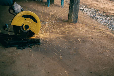 working at home, man holding steel cutter device and workingの写真素材