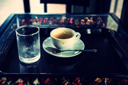 drunk coffee with water in glass on dark table vintage pictureの写真素材