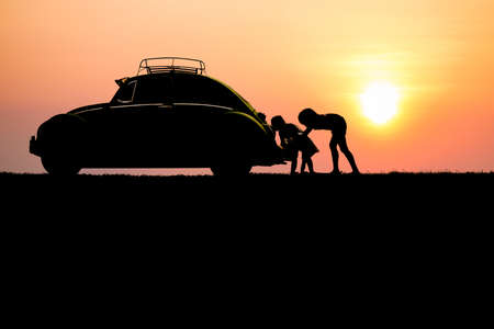 silhouette children pushing broken car, crash engine in evening and hard light