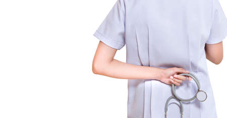 young dotor holding stethoscope behind back isolated on white backgroundの写真素材