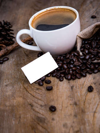 coffee cup with coffee bean on wooden background , white paper for textの写真素材