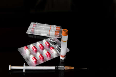 diabetes syringe and capsules medication on black background