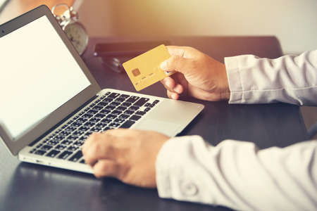 working man putting number of credit card for online shopping