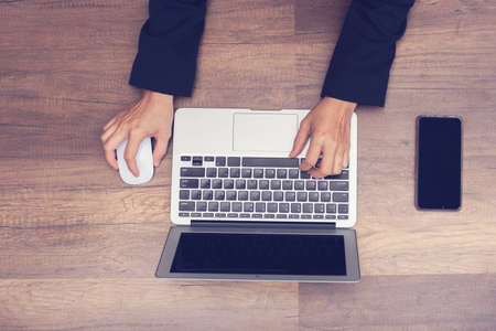 business man working by laptop on wooden background, asian business man working or searching in...