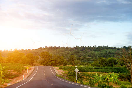 wheel turbine working with blue sky, wind mill on small hill with green forest