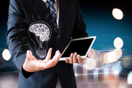 business man holding hand with drawing brain in bulbの写真素材