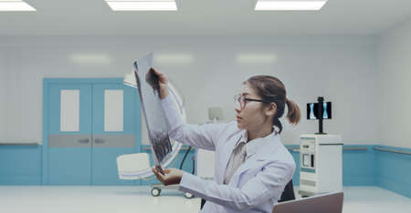 Young doctor holding x-ray and CT can chart to finding injury pointsの写真素材