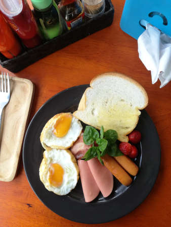 Breakfast Dish is serving on table with cutlery, seasoning and tissue paperの写真素材