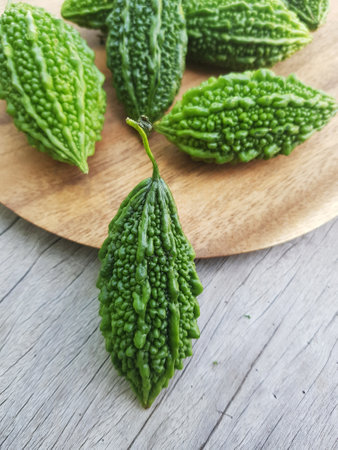 Fresh Bitter gourd or Pavakka on wooden backgroundの写真素材