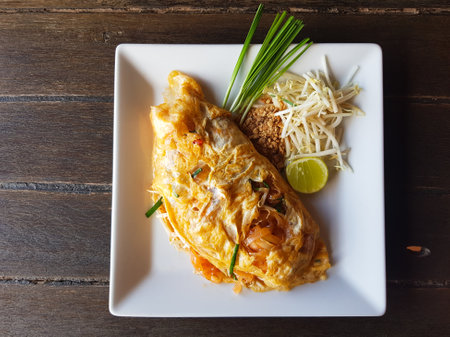Thai Dish of Pad Thai wrapped with Light Omelette and condimentsの写真素材