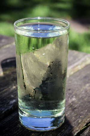 A long, cool drink of lemon and lime on a table in a pub garden