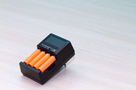 Black charger with orange AAA battery