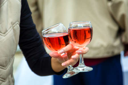 two glasses of wine in woman handの写真素材